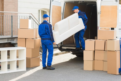 Professional movers carrying items through a Greenwich property